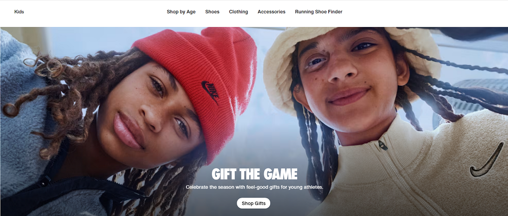 Two kids smiling in Nike winter apparel, wearing cozy jackets and beanies, promoting Nike’s seasonal gift collection for young athletes.